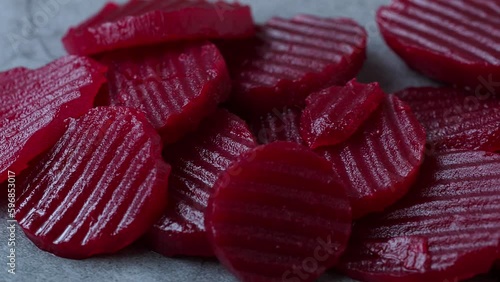 Slices of pickled red beets on black background