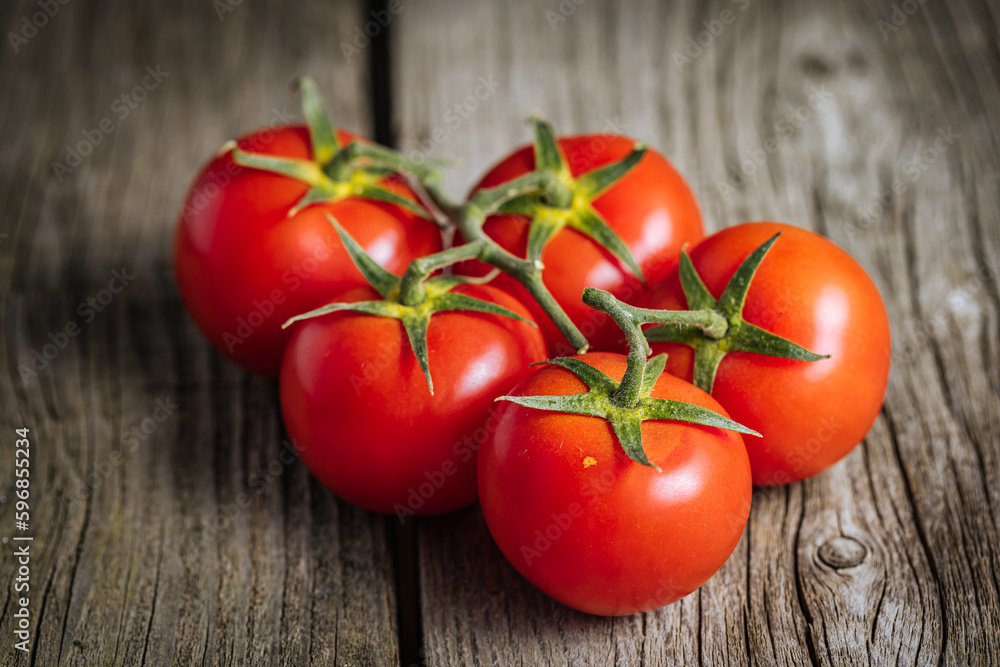 Bunch of fresh, red tomatoes on a wooden rustic board. Healthy and fresh ripe Bunch of fresh, red tomatoes on a wooden rustic board. Healthy and fresh ripe