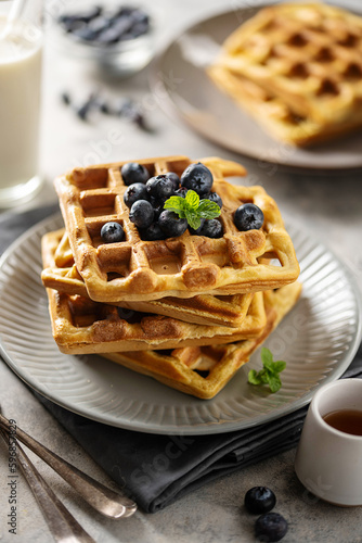 Homemade belgian waffles with blueberries and honey