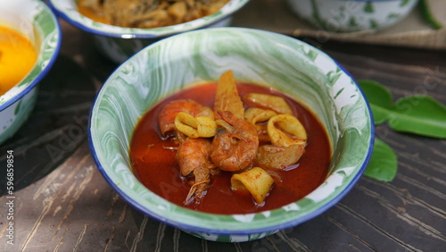 Fried shrimp with tomato sauce in a bowl on wooden table
