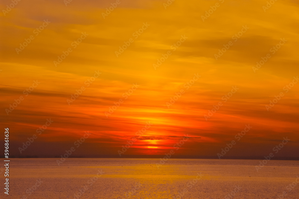 background image: setting sun on the horizon over the water surface