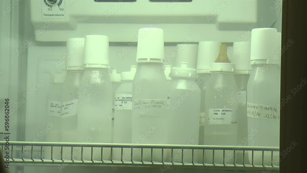 Neonatal Nurse Picking Up Baby Bottle from Fridge in a Neonatal Intensive Care Unit at Hospital. Closeup.