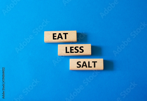 Eat less salt symbol. Concept word Eat less salt on wooden blocks. Beautiful blue background. Business and Eat less salt concept. Copy space