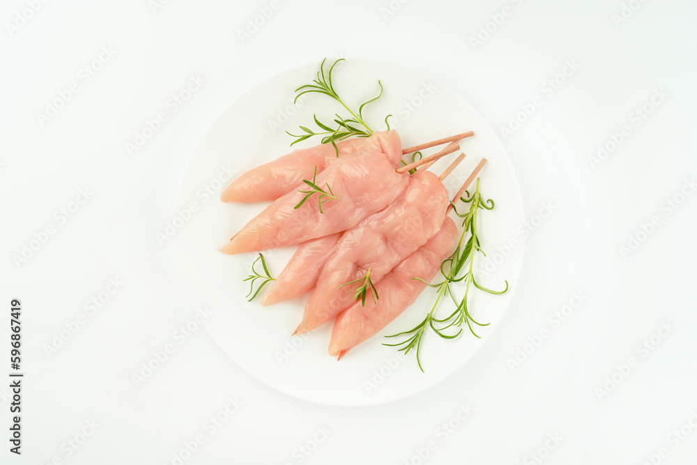 Chicken skewers.Food concept.Skewers from raw chicken meat inner fillet on a white plate for a supermarket on a white background..Ogranic food,healthy eating.Food for retail.Top view. Chicken skewers.Food concept.Skewers from raw chicken meat inner fillet on a white plate for a supermarket on a white background..Ogranic food,healthy eating.Food for retail.Top view.