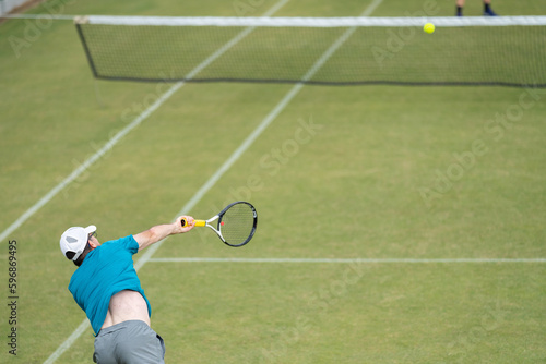 Amateur playing tennis at a tournament and match on grass in Europe