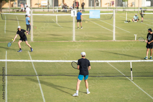 Amateur playing tennis at a tournament and match on grass in Europe