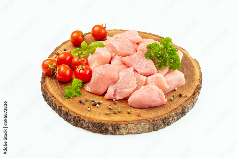 Ogranic food and healthy eating.chicken fillet.Fresh pieces of turkey meat.Raw chicken.Raw pieces of turkey meat with greens and tomatoes on a wooden board against a white background.