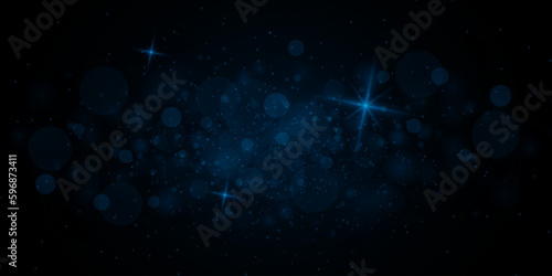 Christmas bokeh lights background. Blue twinkling particles and stars of light.