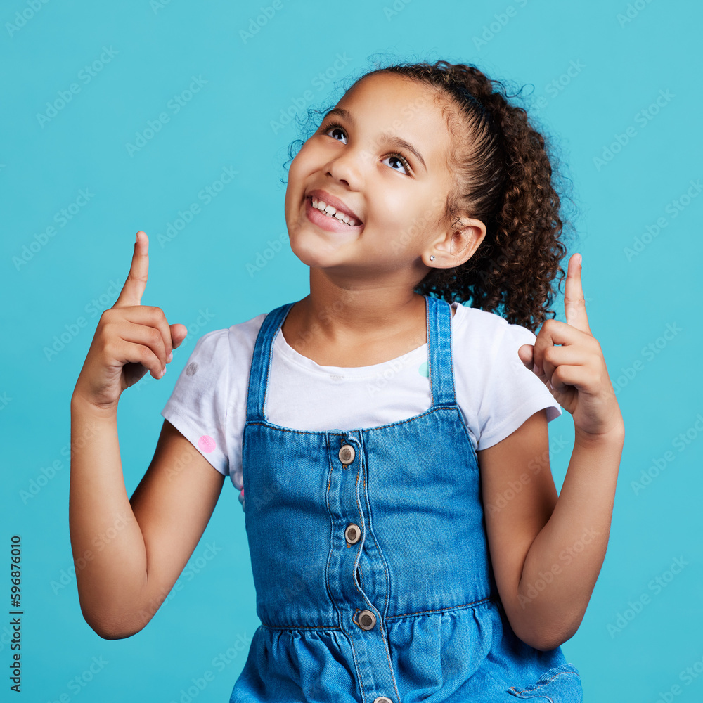This is my idea. Shot of an adorable little girl pointing at something while standing against a blue background. This is my idea. Shot of an adorable little girl pointing at something while standing against a blue background.