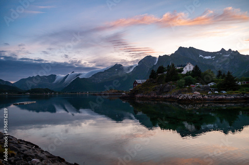Sunset in the evening during the polar night in Norway. Sea and high rocky mountains with clouds. © Jan