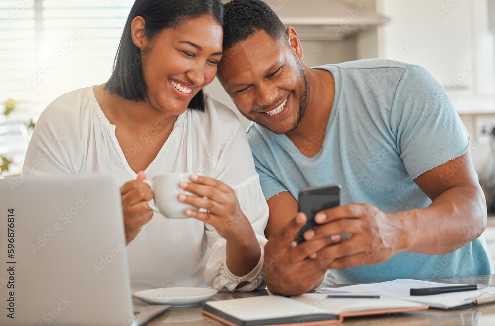 Looks like our application was approved. Shot of a man showing his wife something on his cellphone while sitting at home. Looks like our application was approved. Shot of a man showing his wife something on his cellphone while sitting at home.