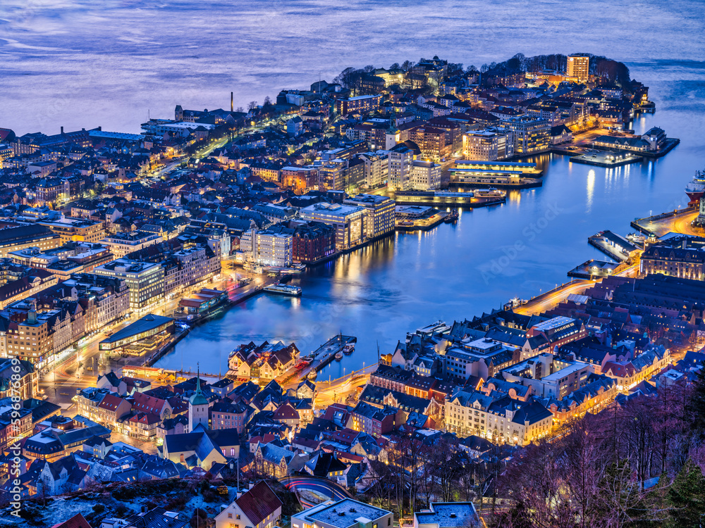Bergen city illiminated with golden street and buildings lights on a winter evening, Norway