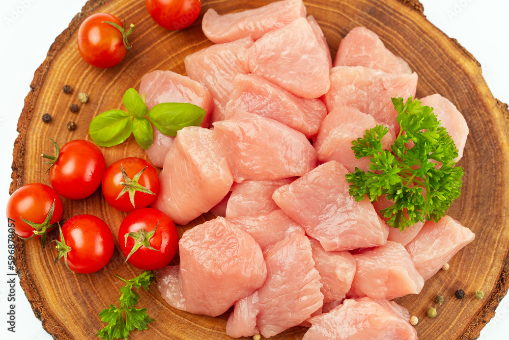 Fresh pieces of turkey meat.Raw chicken.Raw pieces of turkey meat with greens and tomatoes on a wooden board against a white background.Ogranic food and healthy eating.chicken fillet.Close up. Fresh pieces of turkey meat.Raw chicken.Raw pieces of turkey meat with greens and tomatoes on a wooden board against a white background.Ogranic food and healthy eating.chicken fillet.Close up.