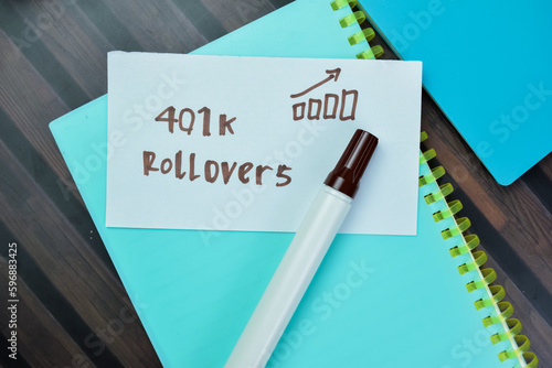 Concept of 401k Rollovers write on sticky notes isolated on Wooden Table. photo