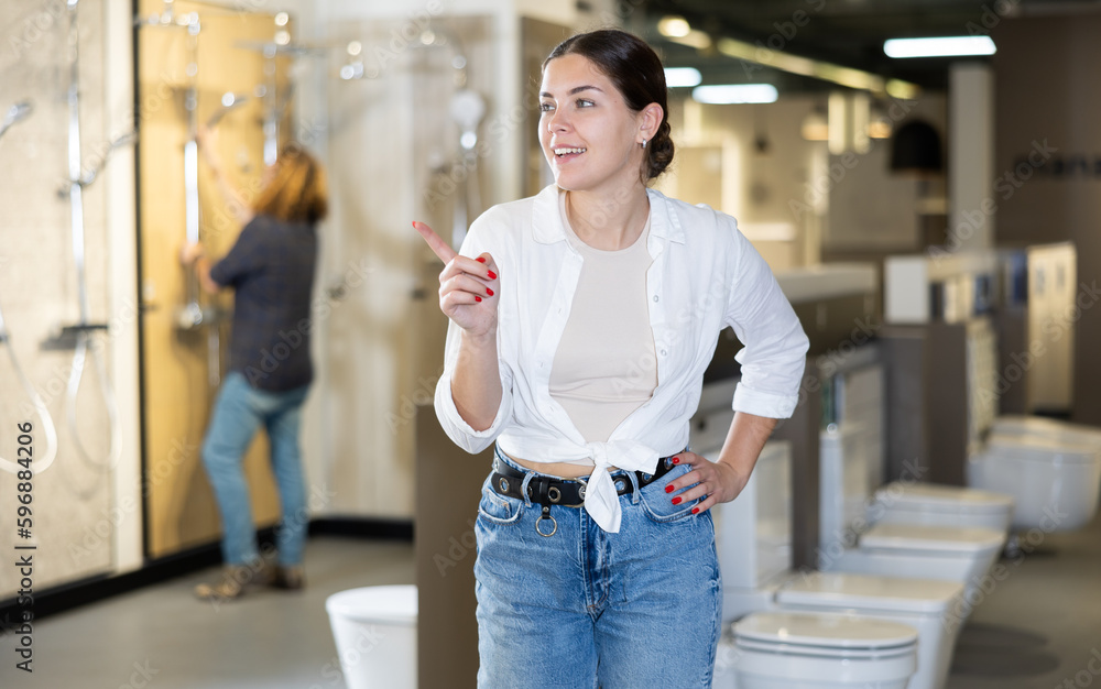 in plumbing department, middle-aged woman thought about choosing suitable bathroom for new apartment