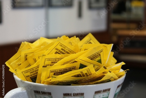 Sachets of bar sugarin a large mug photo