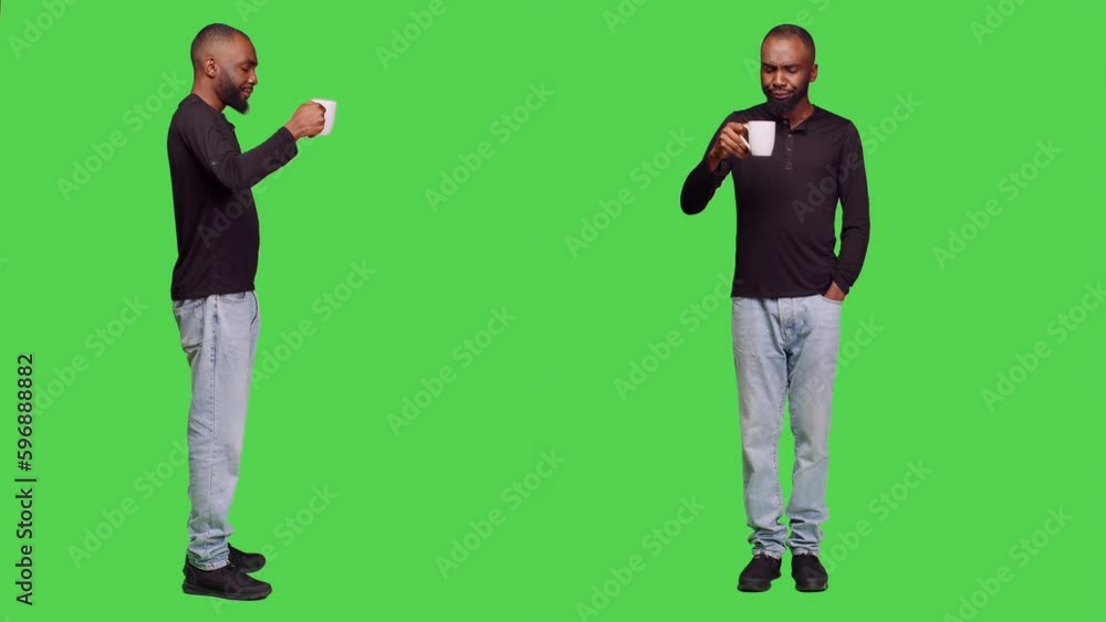 Young person drinking coffee over full body greenscreen, serving cup of caffeine beverage in studio. Confident man enjoying refreshment drink on camera wearing jeans, leisure activity. Young person drinking coffee over full body greenscreen, serving cup of caffeine beverage in studio. Confident man enjoying refreshment drink on camera wearing jeans, leisure activity.