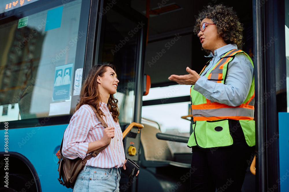 Female driver communicating with commuter at bus station. Female driver communicating with commuter at bus station.