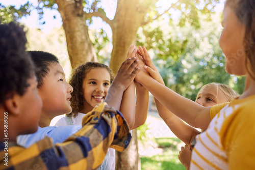 Turns out exercise can be fun. Shot of a group of kids giving each other a high five at summer camp.