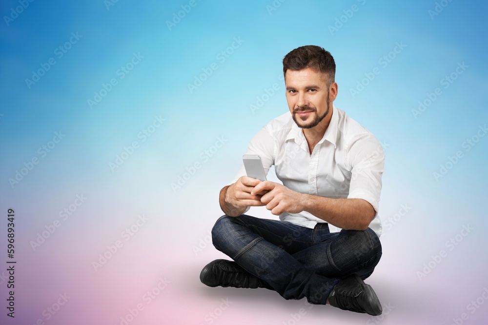 Smiling young man hold mobile phone in hands