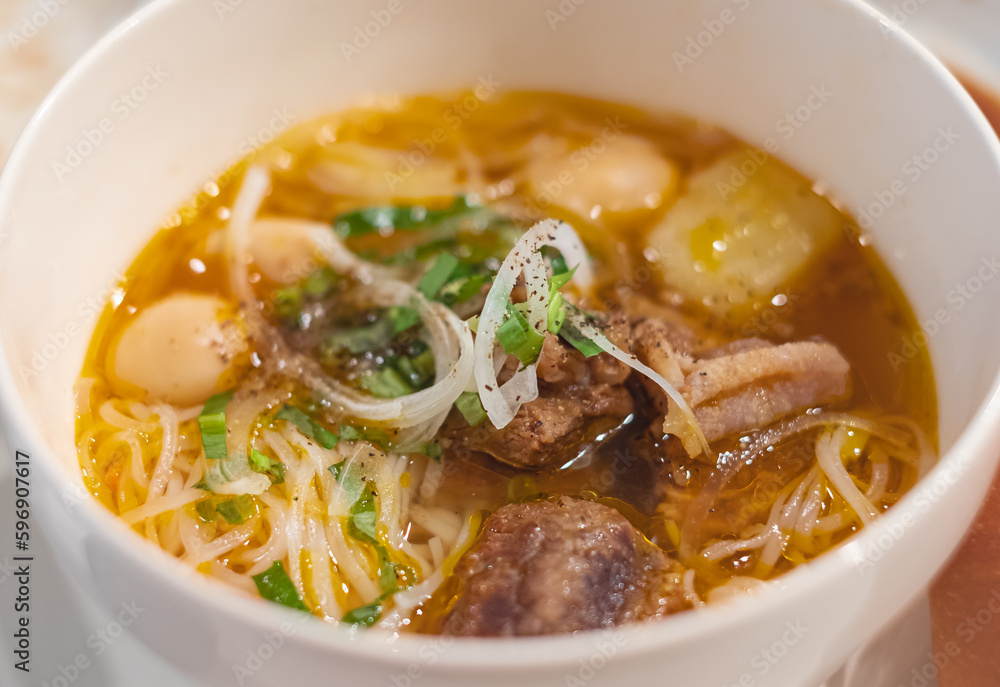 Homemade beef vegetable soup in a white bowl. Delicious noodles soup in a bowl with bread. Meat soup with vegetables Homemade beef vegetable soup in a white bowl. Delicious noodles soup in a bowl with bread. Meat soup with vegetables