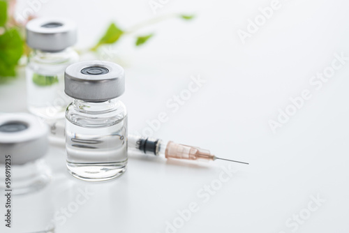 白背景にワクチンの入ったバイアル瓶と注射器　病院や医療のイメージ写真