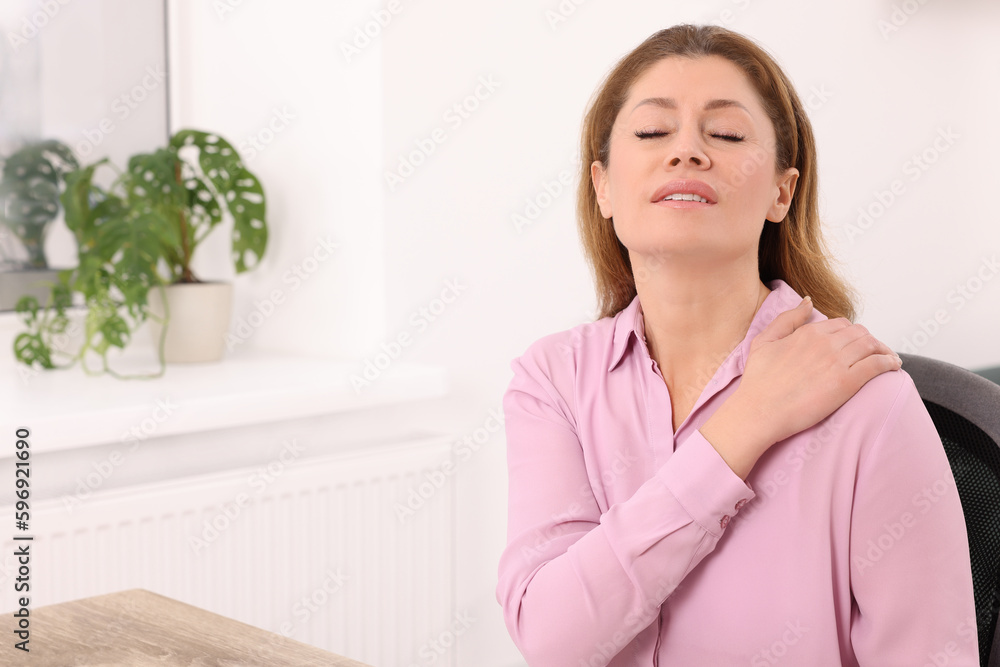 Woman suffering from pain in shoulder indoors, space for text. Arthritis symptoms Woman suffering from pain in shoulder indoors, space for text. Arthritis symptoms