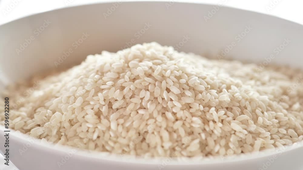 white Rice pour into a bowl. rice plate. Round grain white polished rice .Long shelf life products. carbohydrate food. High quality 4k footage white Rice pour into a bowl. rice plate. Round grain white polished rice .Long shelf life products. carbohydrate food. High quality 4k footage