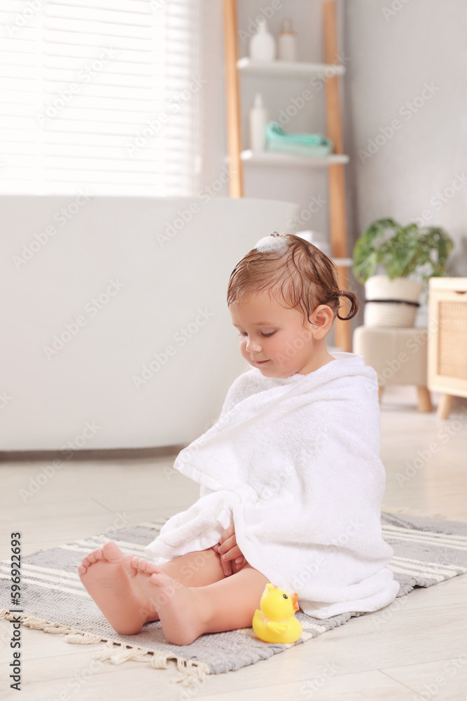 Cute little girl wrapped with towel after bath in room Cute little girl wrapped with towel after bath in room