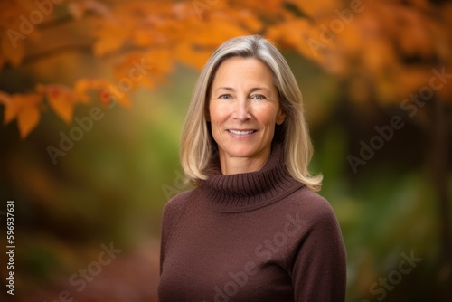 Portrait of a beautiful mature woman in the autumn forest. Smiling. © Anne-Marie Albrecht