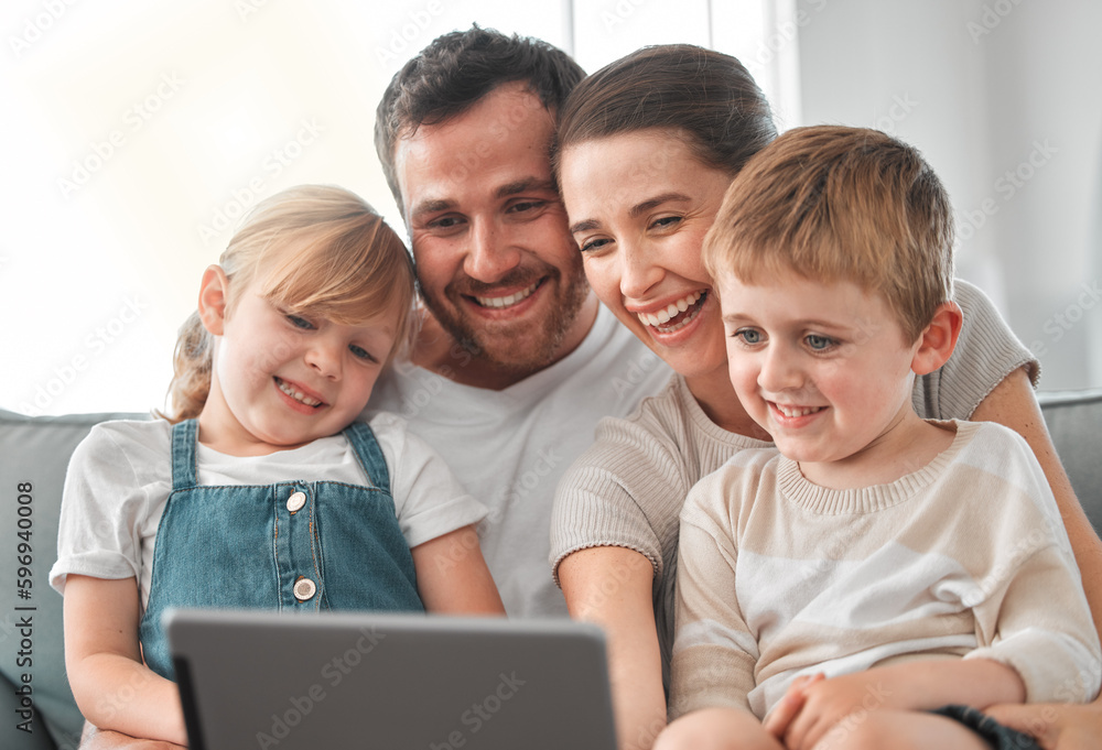 A happy home is a warm home. Shot of a young family using a digital tablet at home. A happy home is a warm home. Shot of a young family using a digital tablet at home.