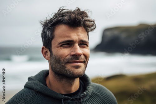 Portrait of handsome man standing on the beach with ocean in background