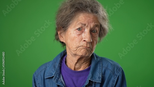 Photography Funny crazy closeup portrait of happy toothless elderly senior old woman with wrinkled skin and grey hair shrugging shoulders and gesturing I do not know isolated on green screen background