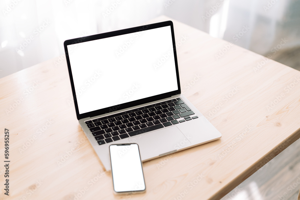 Smartphone and laptop with blank screens for text or advertising on wooden table. Smartphone and laptop with blank screens for text or advertising on wooden table.