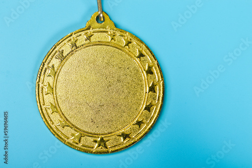 An empty gold medal with copy space is a representation of the concept of celebration and ceremony, as well as a symbol of victory and sporting achievements.