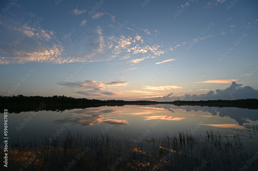 Colorful sunrise cloudscape reflected in calm water of Nine Mile Pond in Everglades National Park, Florida.