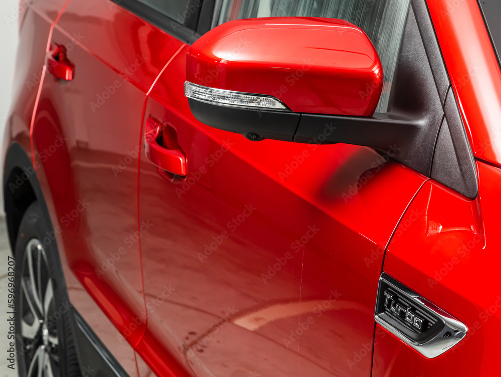  Side mirror of a  red car close-up. Exterior detail
