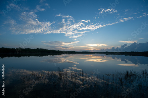 Colorful sunrise cloudscape reflected in calm water of Nine Mile Pond in Everglades National Park, Florida.