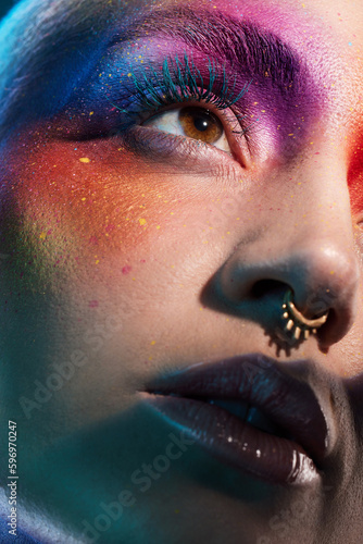 We werent meant to fit in. Studio shot of a young woman posing with multi-coloured paint on her face. photo