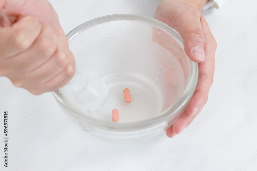 粉砕指示と薬剤師。乳鉢に錠剤があり、乳棒で砕いている