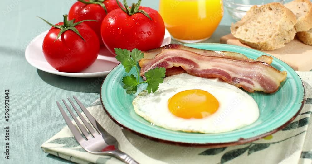fried eggs with bacon on a plate. breakfast with fresh vegetables and bread on the table. sunny morning. country style. organic farm food fried eggs with bacon on a plate. breakfast with fresh vegetables and bread on the table. sunny morning. country style. organic farm food