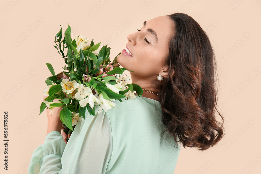 Young woman in dress with alstroemeria flowers on beige background, closeup Young woman in dress with alstroemeria flowers on beige background, closeup