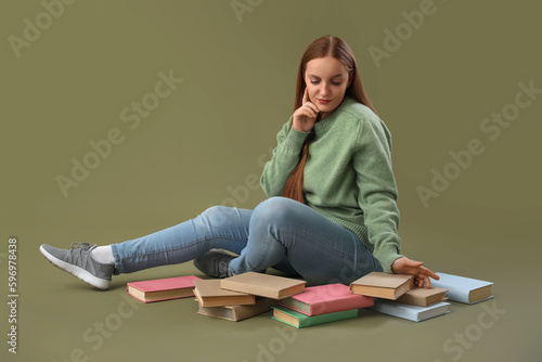 Education and lifelong learning, young woman sitting on floor with books stud...