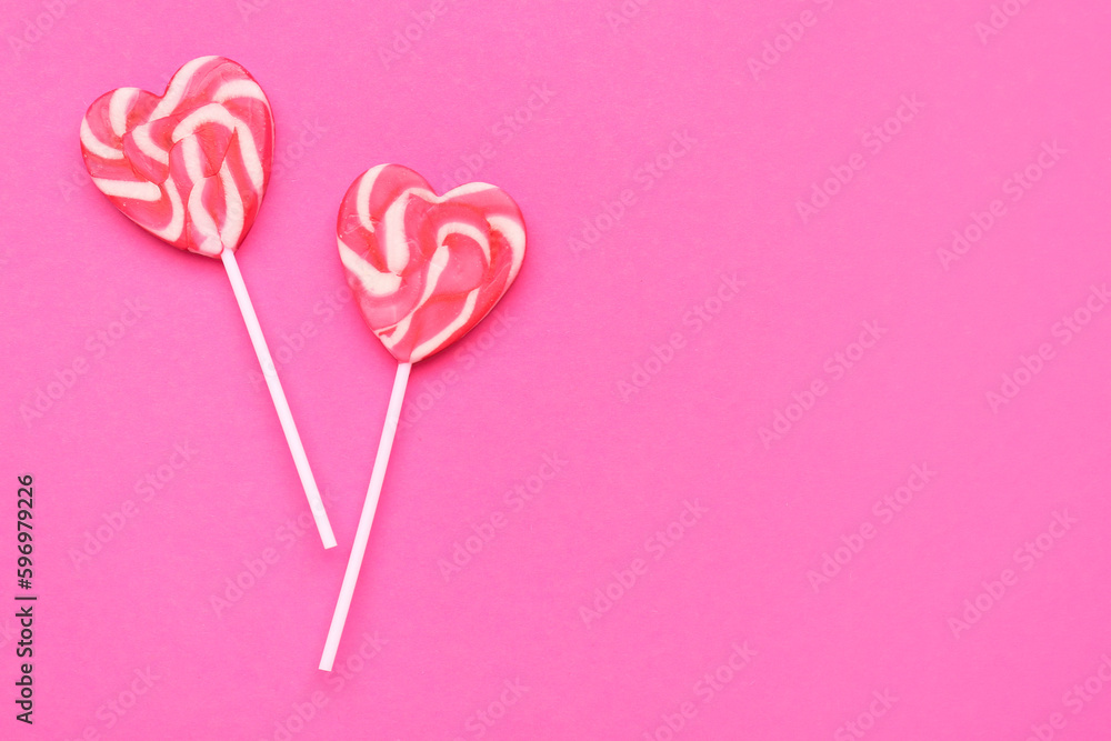 Heart shaped lollipops on pink background