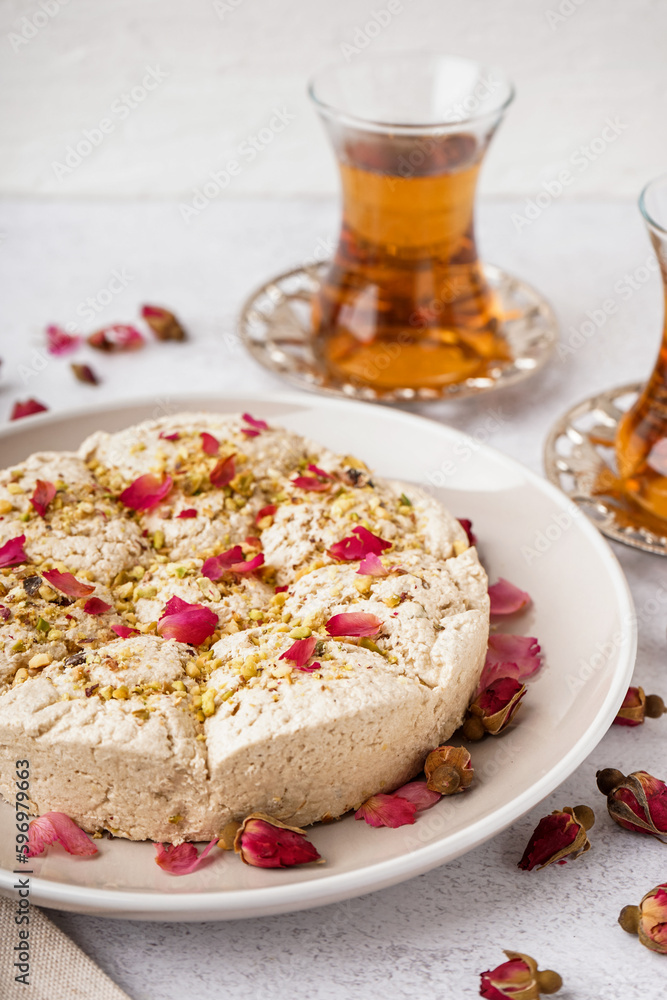 Plate of tasty Tahini halva with pistachios on light background, closeup Plate of tasty Tahini halva with pistachios on light background, closeup