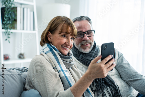 Caucasian senior couple video call with family in living room at home. 