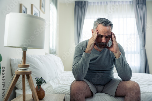 Caucasian senior older depressed man sitting alone in bedroom at home. 