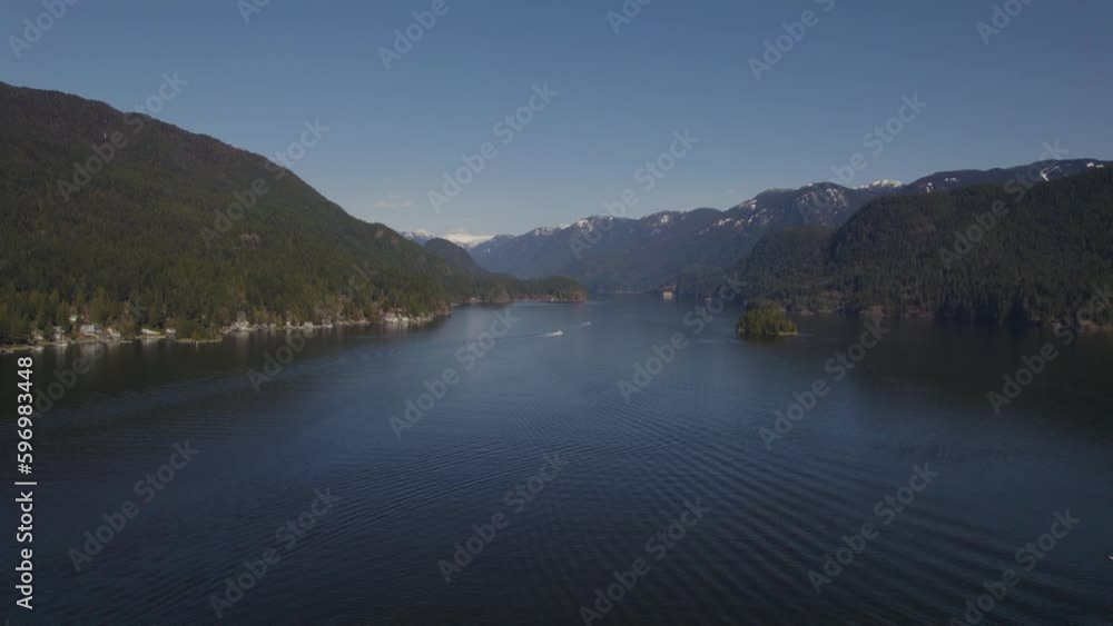 Aerial view of ocean inlet surrounded by mountains with an island in the foreground near Vancouver, BC on a bright summers day Aerial view of ocean inlet surrounded by mountains with an island in the foreground near Vancouver, BC on a bright summers day