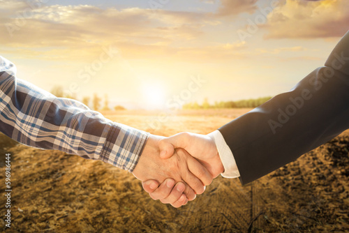 Business concept.Business handshake land purchase. Empty dry cracked swamp reclamation soil in real estate sale or property investment concept. Agriculture land plot for sales.