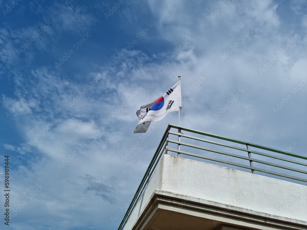 Taegeukgi waving in the blue sky.
Taegeukgi waving in the blue sky.